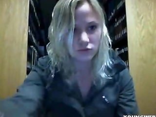 pretty blonde teen striping in a public library